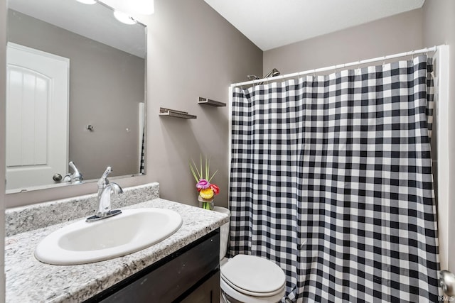 bathroom featuring toilet, curtained shower, and vanity