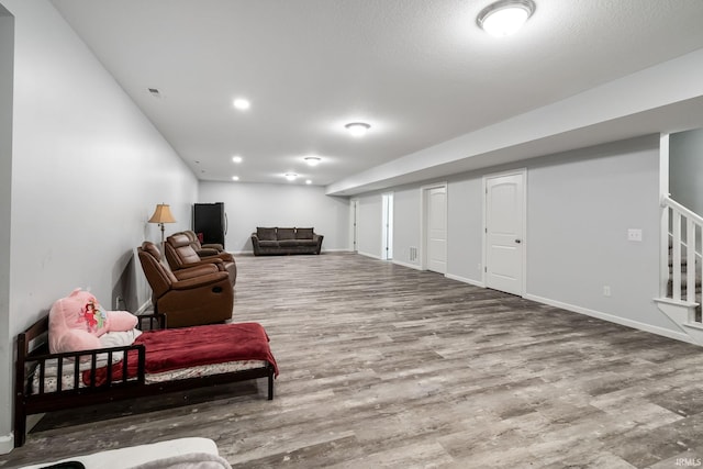 sitting room with baseboards, stairs, visible vents, and wood finished floors