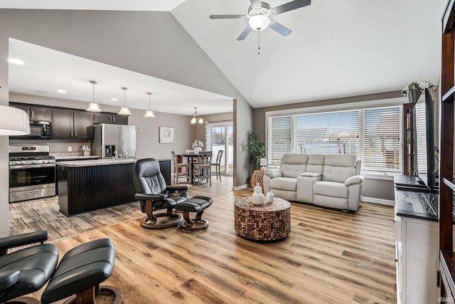 living room featuring high vaulted ceiling, light wood finished floors, baseboards, and a ceiling fan