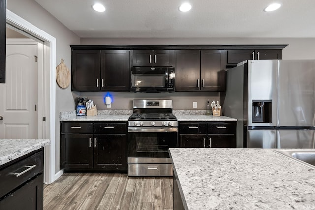 kitchen with appliances with stainless steel finishes, recessed lighting, light countertops, and light wood-style floors