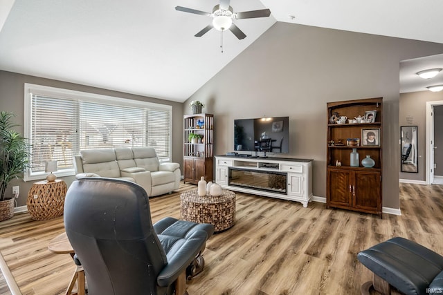 living room featuring ceiling fan, high vaulted ceiling, light wood-style flooring, and baseboards