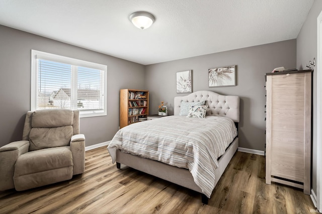 bedroom featuring baseboards and wood finished floors