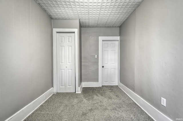 unfurnished bedroom with a closet, carpet flooring, and baseboards