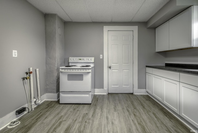 kitchen featuring electric range, light wood-style flooring, and baseboards