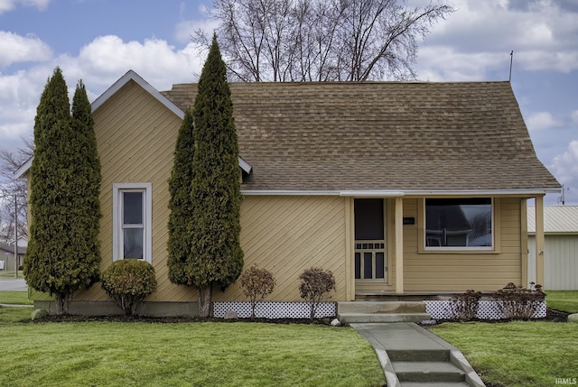 view of front of property featuring a front yard and roof with shingles