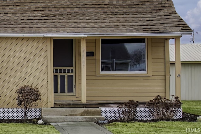 doorway to property featuring a shingled roof