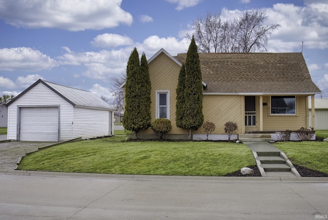 view of front of property with a garage, a shingled roof, an outdoor structure, driveway, and a front yard