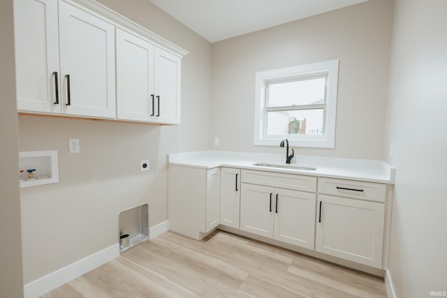 washroom with cabinet space, a sink, hookup for a washing machine, light wood-type flooring, and electric dryer hookup