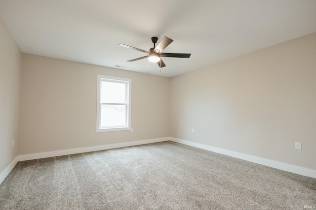 spare room with carpet, visible vents, ceiling fan, and baseboards