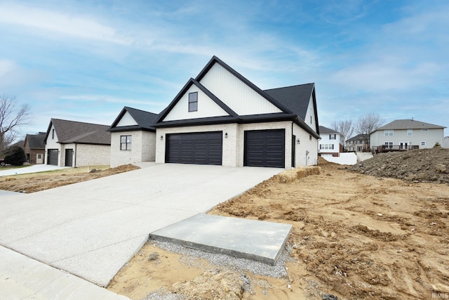 modern farmhouse featuring driveway, brick siding, an attached garage, and a residential view