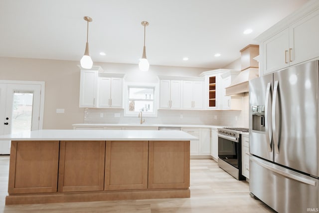 kitchen with a center island, stainless steel appliances, light countertops, a sink, and premium range hood