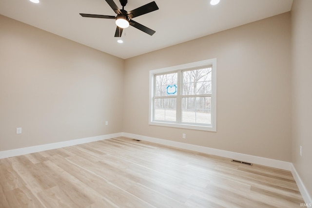 empty room with recessed lighting, visible vents, light wood finished floors, and baseboards