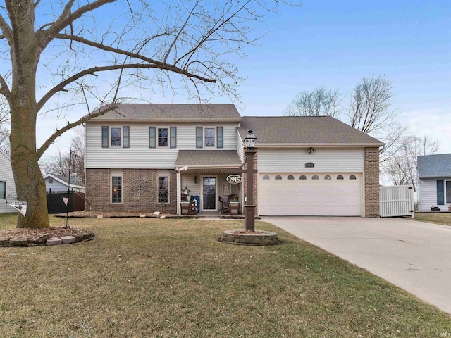 traditional-style house with a front yard, concrete driveway, brick siding, and an attached garage