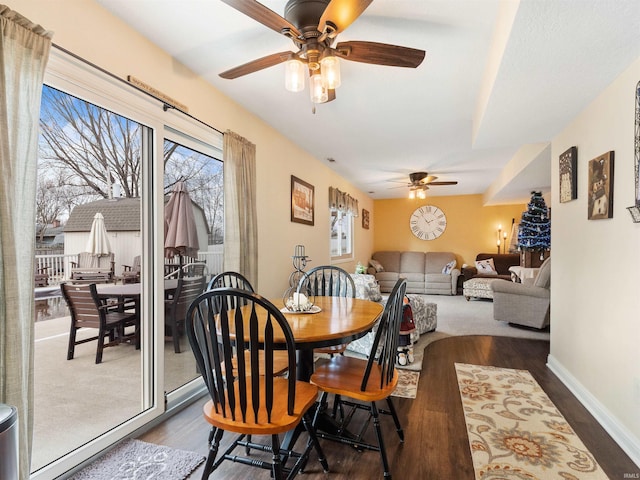 dining area featuring dark wood finished floors, a ceiling fan, and baseboards