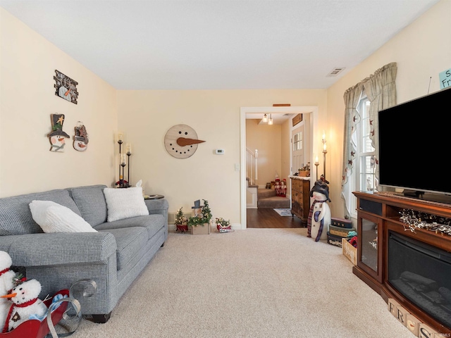 living area featuring carpet flooring and stairs