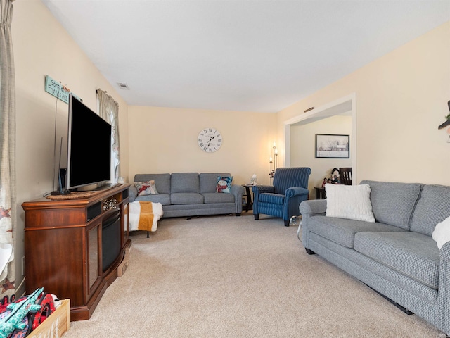 living area with visible vents and light colored carpet