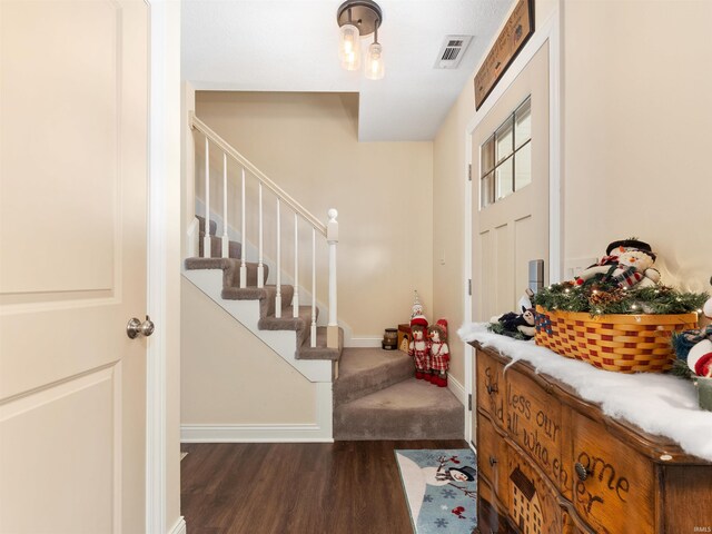 foyer entrance with stairs, wood finished floors, visible vents, and baseboards