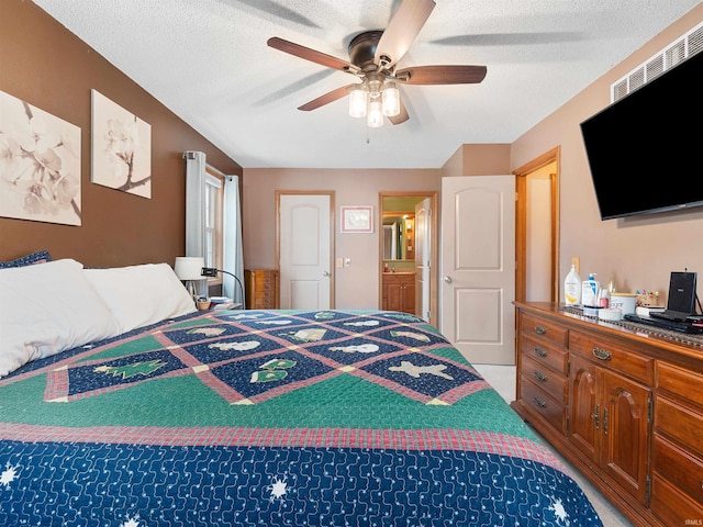 bedroom with a ceiling fan, light colored carpet, and a textured ceiling