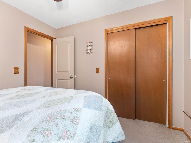 bedroom featuring ceiling fan, a closet, and light colored carpet