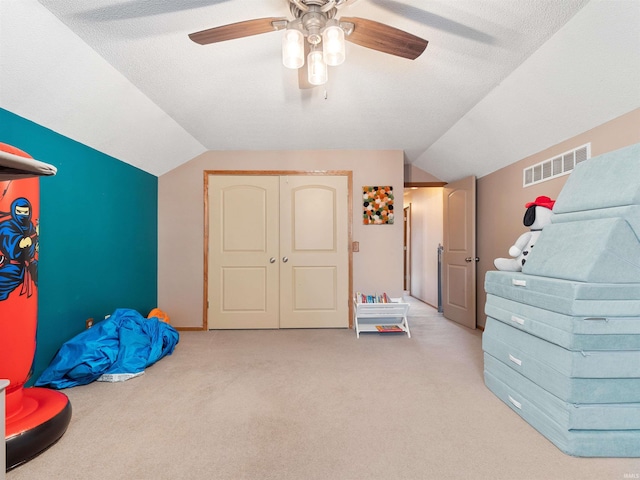 game room with visible vents, vaulted ceiling, a ceiling fan, and light colored carpet