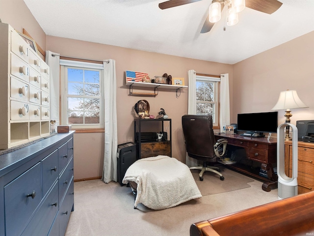 office area featuring a ceiling fan, light colored carpet, and baseboards