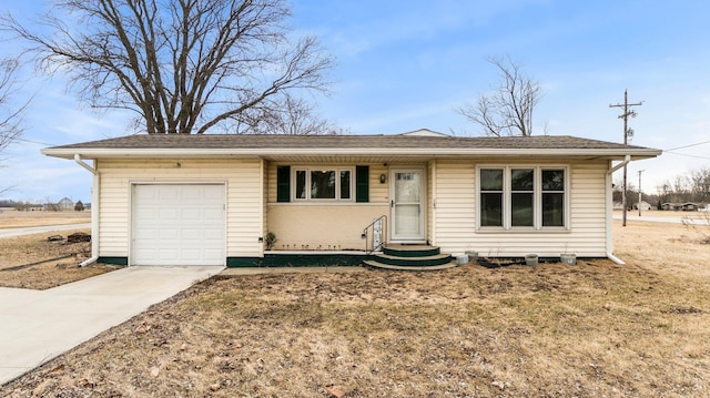 ranch-style home with entry steps, concrete driveway, roof with shingles, and an attached garage