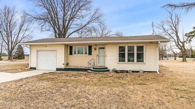 ranch-style house with a front lawn, entry steps, concrete driveway, and an attached garage