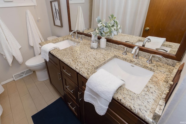 full bathroom with visible vents, a sink, toilet, and double vanity