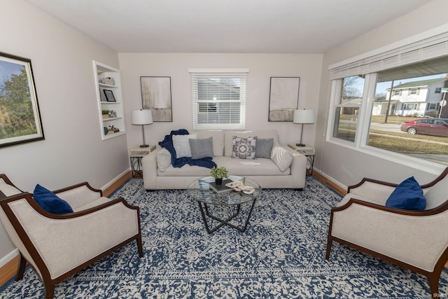 living area featuring built in shelves and baseboards