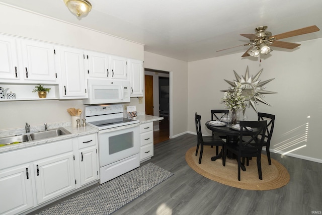 kitchen with white appliances, white cabinets, dark wood-style flooring, light countertops, and a sink