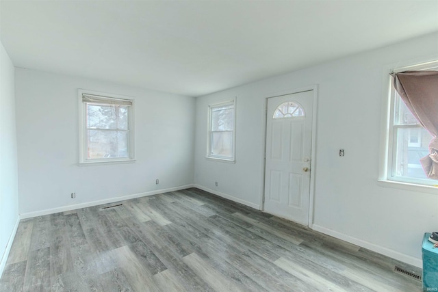 foyer with visible vents, baseboards, and wood finished floors