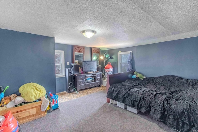 bedroom with a textured ceiling, multiple windows, and carpet flooring