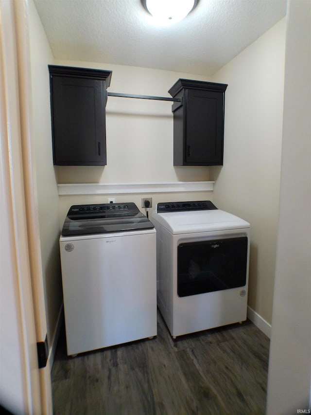 laundry area with cabinet space, dark wood finished floors, a textured ceiling, and washing machine and clothes dryer