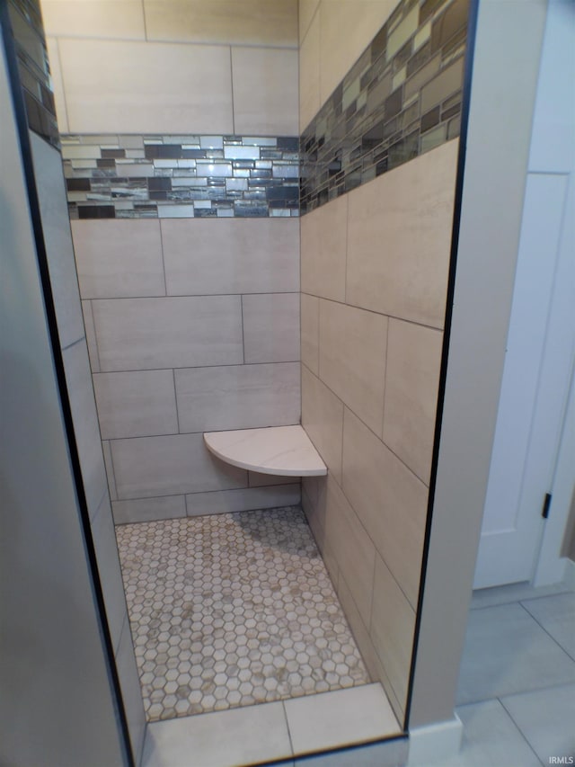 full bathroom with a tile shower and tile patterned floors