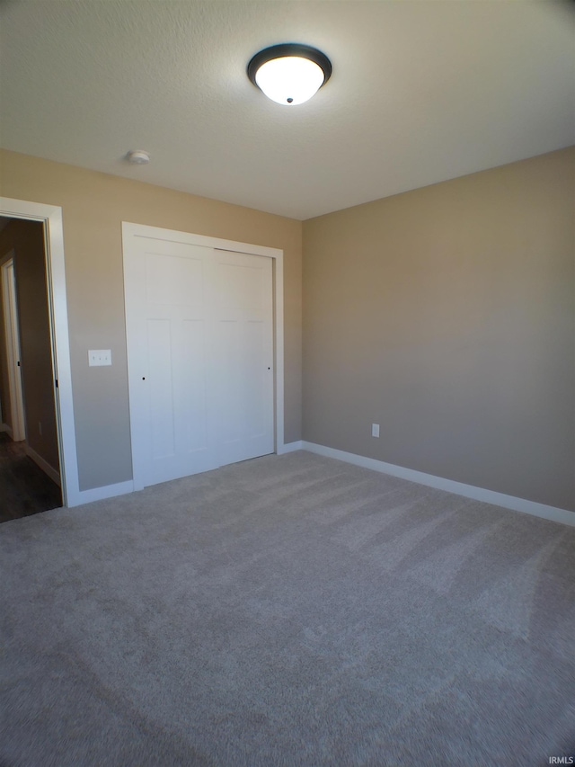 unfurnished bedroom featuring carpet flooring and baseboards