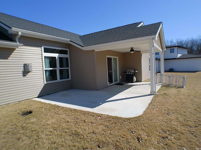 back of property with a shingled roof, a patio area, and a ceiling fan