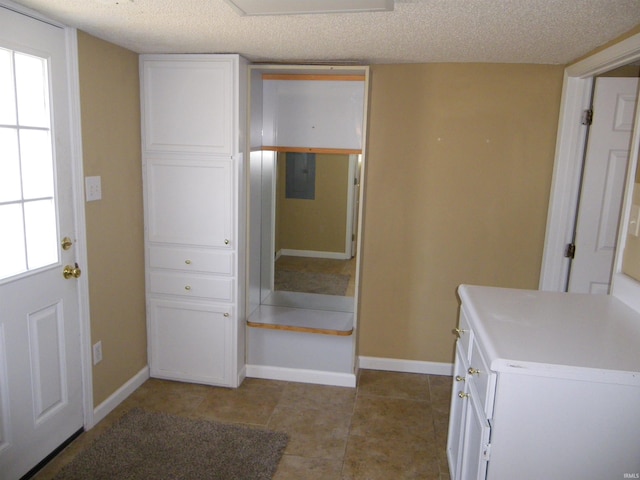 interior space featuring plenty of natural light, baseboards, and a textured ceiling