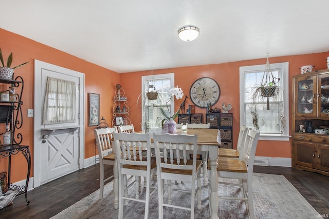 dining room featuring plenty of natural light, wood finished floors, and baseboards