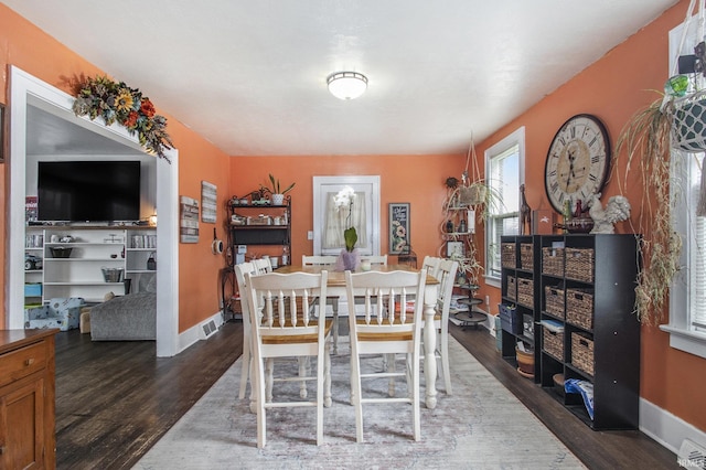 dining room featuring wood finished floors, visible vents, and baseboards