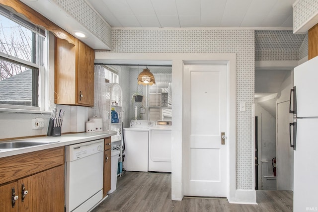 kitchen featuring white appliances, wood finished floors, light countertops, brown cabinets, and washing machine and clothes dryer