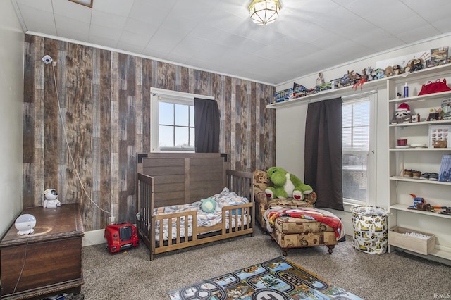 bedroom featuring carpet floors and wooden walls