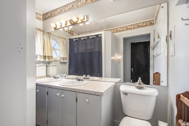 bathroom with double vanity, curtained shower, a sink, and toilet