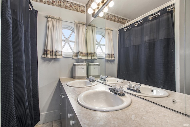 full bathroom with double vanity and a sink