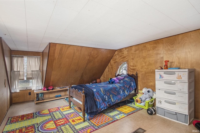 bedroom with wooden walls and tile patterned floors