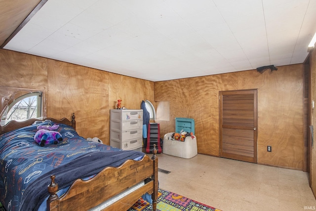 bedroom featuring wood walls and tile patterned floors