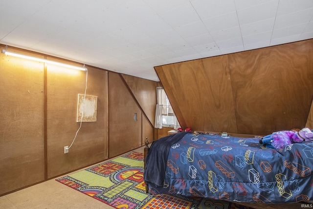 bedroom with carpet floors and wooden walls