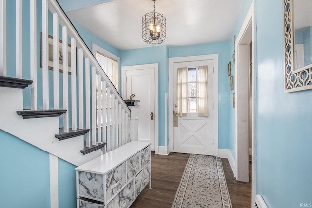 foyer with dark wood-type flooring, a baseboard radiator, baseboards, and stairs