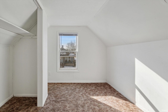 additional living space with carpet flooring, vaulted ceiling, and baseboards