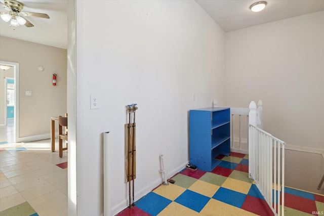 interior space with an upstairs landing, baseboards, and tile patterned floors