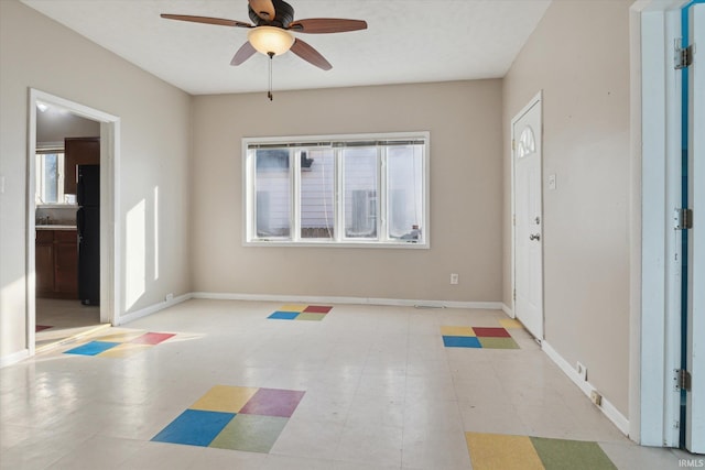 foyer with a ceiling fan, baseboards, and tile patterned floors